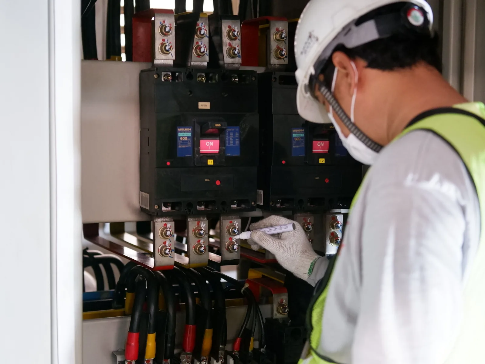 Technicien contrôlant un tableau électrique intérieur